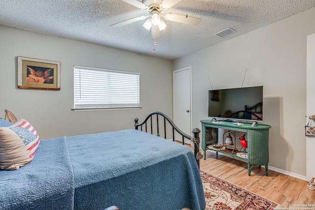 bedroom featuring ceiling fan, a textured ceiling, and hardwood / wood-style flooring