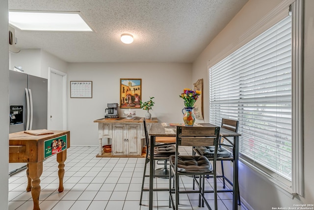 tiled dining room featuring a textured ceiling