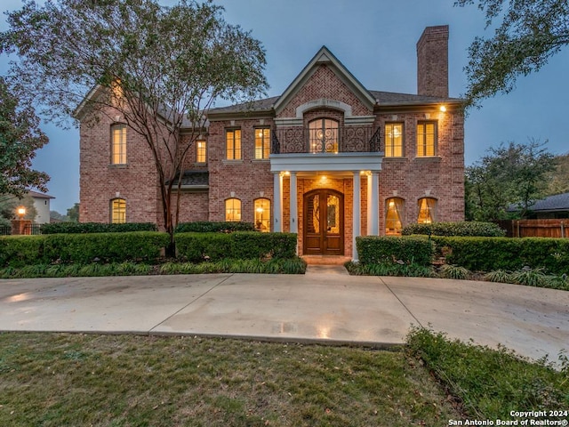 view of front of property featuring a balcony and french doors