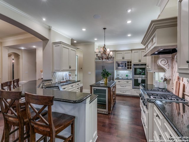 kitchen with dark hardwood / wood-style flooring, backsplash, pendant lighting, built in appliances, and wine cooler