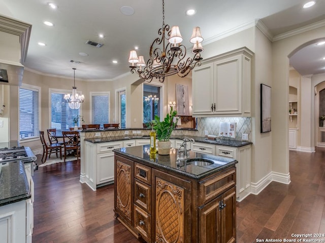 kitchen featuring kitchen peninsula, pendant lighting, dark wood-type flooring, and an island with sink