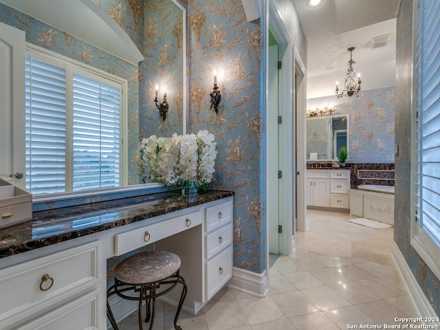 bathroom featuring a bath, vanity, an inviting chandelier, and tile patterned floors