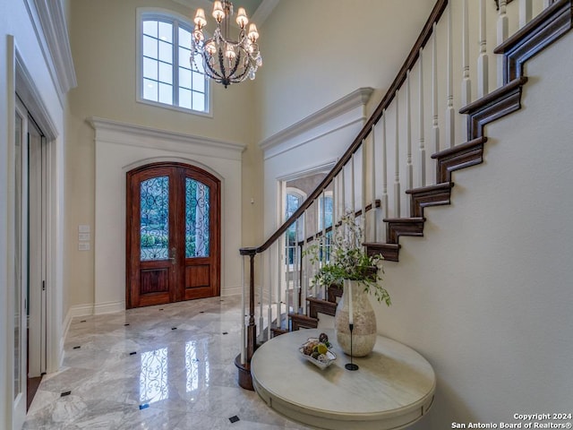 foyer with a chandelier, french doors, and a high ceiling