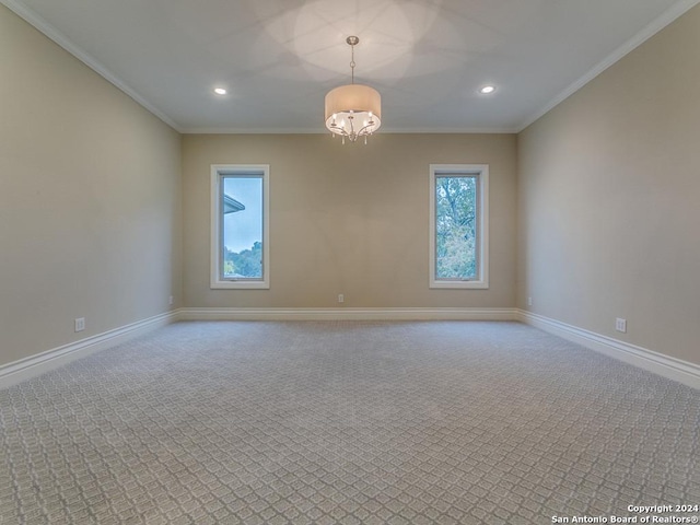 empty room featuring carpet flooring, crown molding, and a notable chandelier