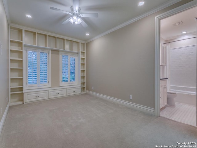 carpeted spare room with ceiling fan and ornamental molding