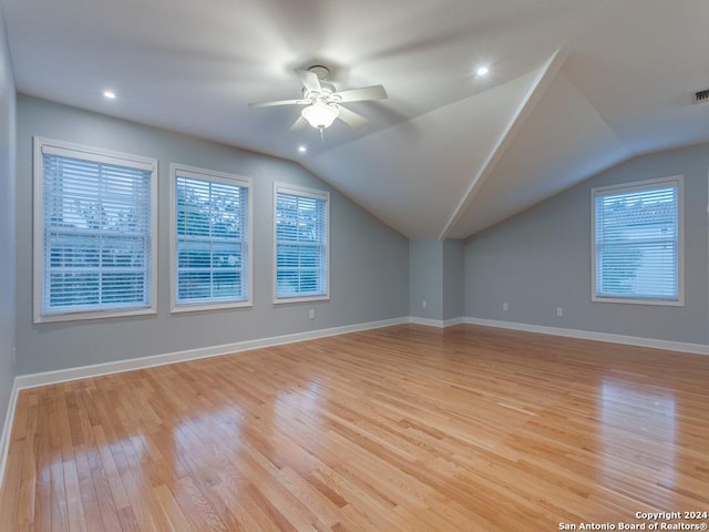 additional living space with ceiling fan, light hardwood / wood-style floors, and vaulted ceiling