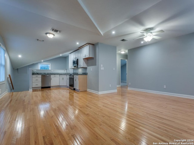 unfurnished living room featuring light wood-type flooring, vaulted ceiling, ceiling fan, and sink