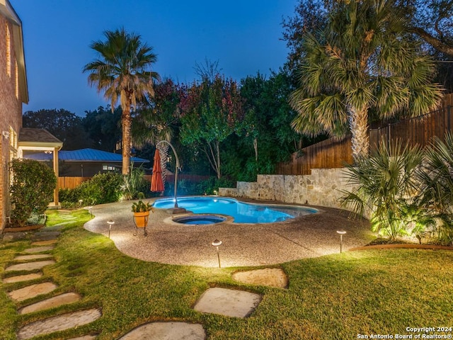 view of pool featuring a lawn and an in ground hot tub