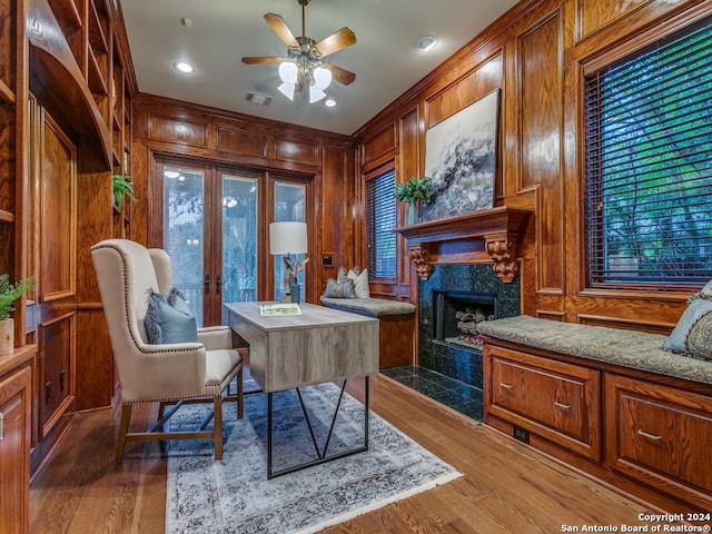 home office with a fireplace, wood-type flooring, ceiling fan, and wooden walls