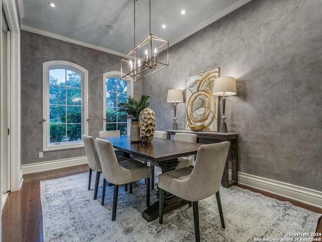 dining space with hardwood / wood-style flooring, a notable chandelier, and ornamental molding