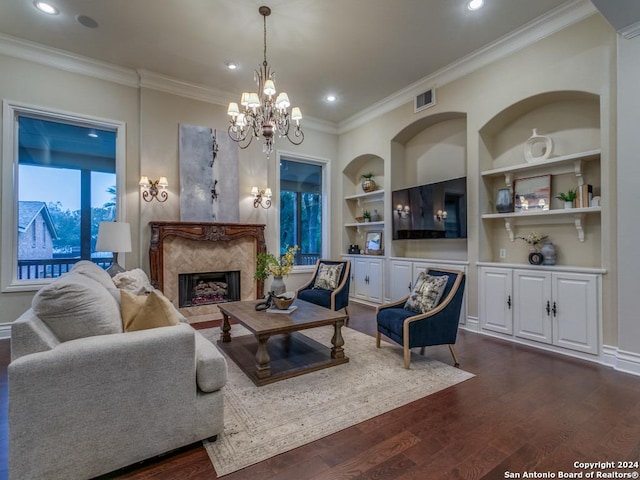 living room with built in shelves, dark wood-type flooring, a high end fireplace, a chandelier, and ornamental molding