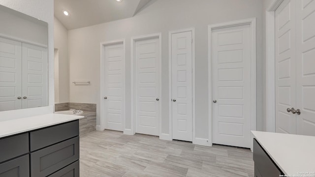 bathroom with vanity and a washtub