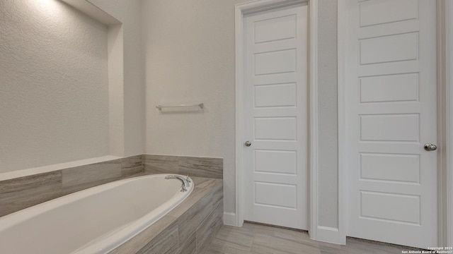 bathroom featuring tiled tub