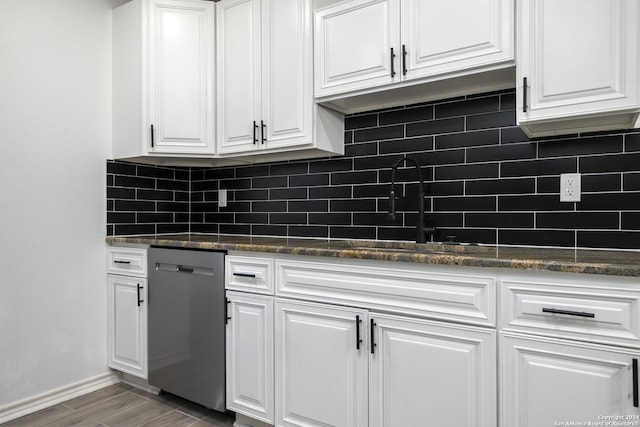 kitchen with stainless steel dishwasher, white cabinets, and tasteful backsplash