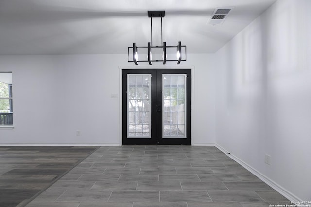 foyer featuring french doors, dark hardwood / wood-style floors, and an inviting chandelier