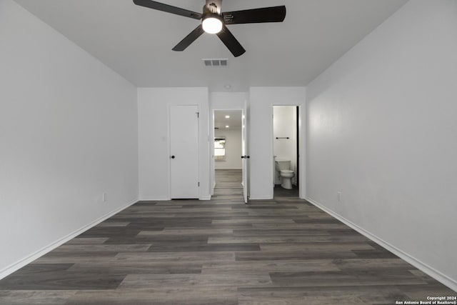 unfurnished bedroom featuring connected bathroom, dark hardwood / wood-style floors, and ceiling fan