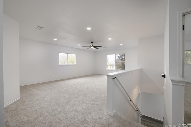 carpeted spare room with ceiling fan