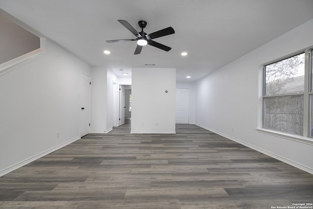 unfurnished living room with dark hardwood / wood-style floors and ceiling fan