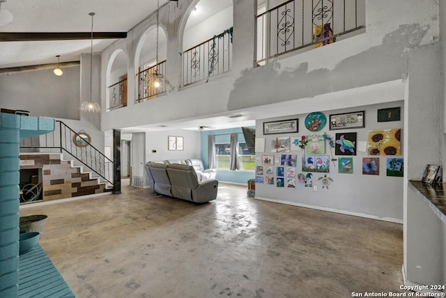 living room featuring a towering ceiling and concrete floors