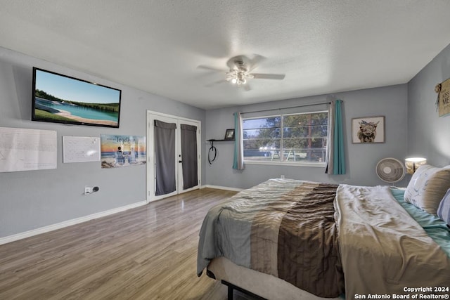 bedroom with wood-type flooring, a textured ceiling, and ceiling fan