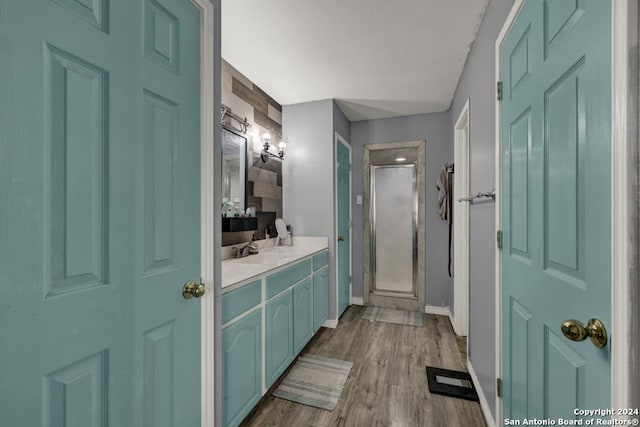 bathroom with walk in shower, vanity, a textured ceiling, and hardwood / wood-style flooring