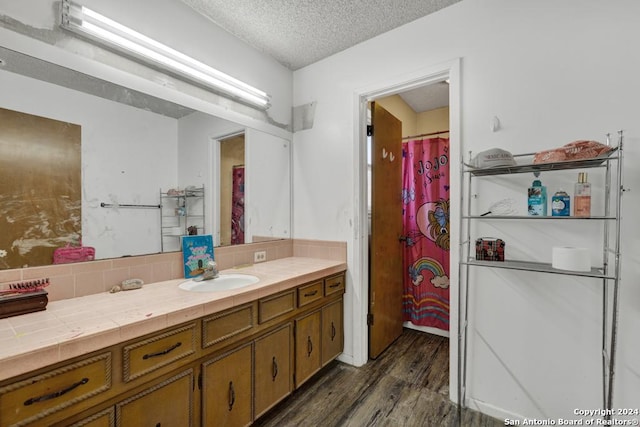 bathroom featuring wood-type flooring, vanity, and a textured ceiling