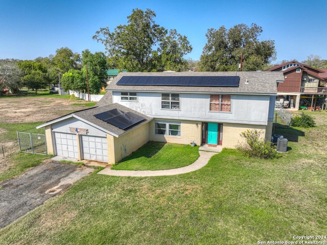 view of front facade with solar panels, a garage, an outbuilding, and a front yard