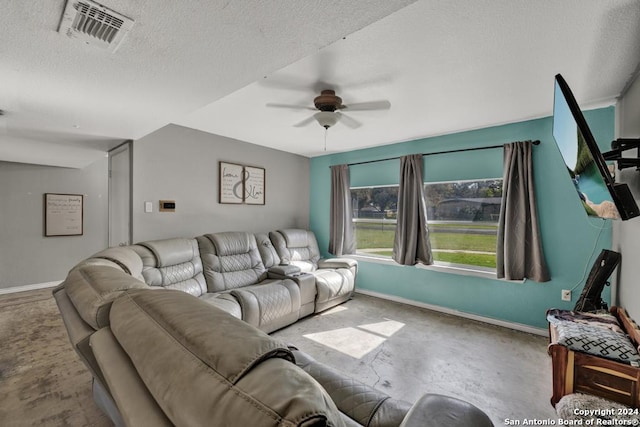 living room with ceiling fan, concrete flooring, and a textured ceiling