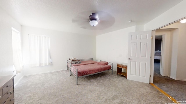 carpeted bedroom with a textured ceiling and ceiling fan