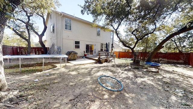 rear view of property featuring a patio and a trampoline