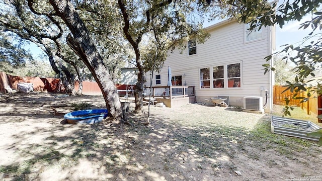 view of yard with central AC unit and a wooden deck