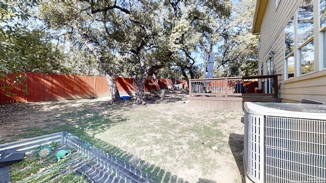 view of yard with central AC and a deck