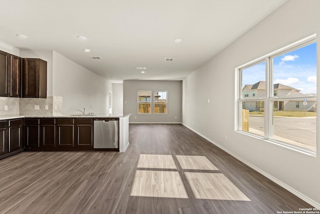 kitchen featuring decorative backsplash, a wealth of natural light, stainless steel dishwasher, and dark hardwood / wood-style floors