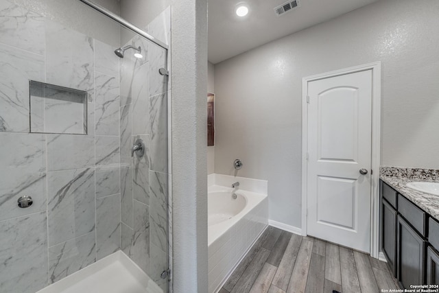 bathroom featuring hardwood / wood-style floors, vanity, and separate shower and tub