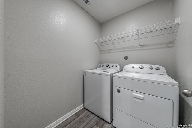 laundry room with hardwood / wood-style flooring and washing machine and clothes dryer