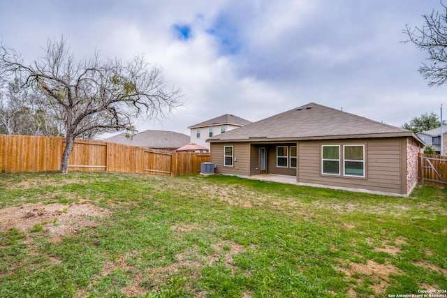 rear view of property featuring a yard, a patio, and central AC unit