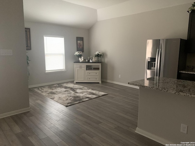 dining space with dark hardwood / wood-style flooring and vaulted ceiling