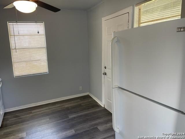 unfurnished room with plenty of natural light, ceiling fan, and dark hardwood / wood-style flooring