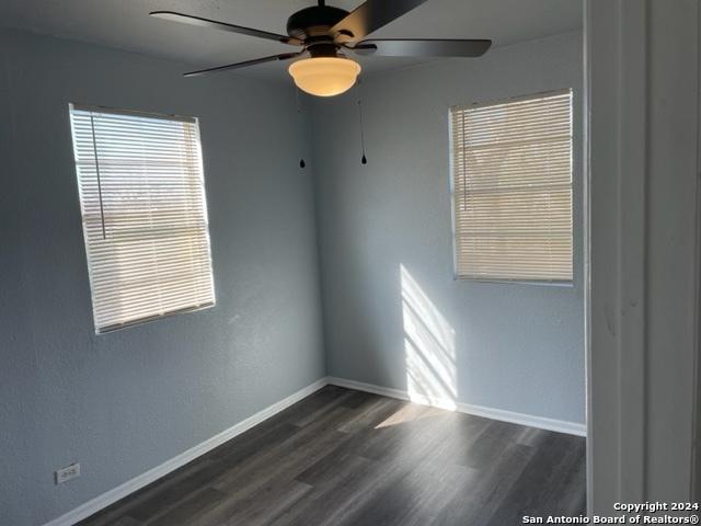 unfurnished room featuring ceiling fan and dark hardwood / wood-style flooring