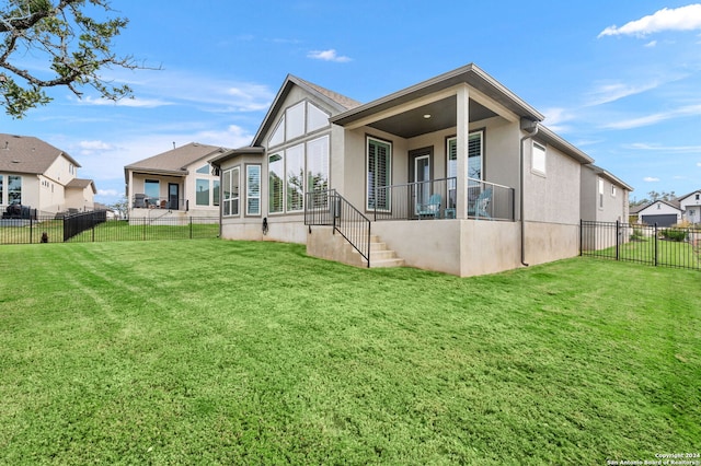 rear view of property featuring a yard