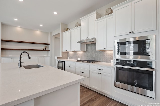 kitchen featuring stainless steel appliances, white cabinetry, dark wood-type flooring, and sink