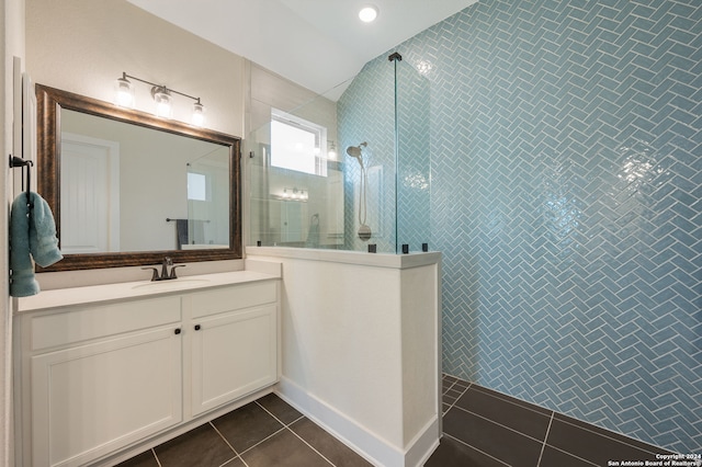 bathroom with tile patterned floors, vanity, and tiled shower