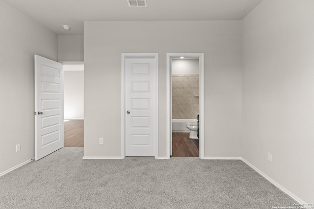 unfurnished bedroom featuring carpet flooring and ensuite bathroom