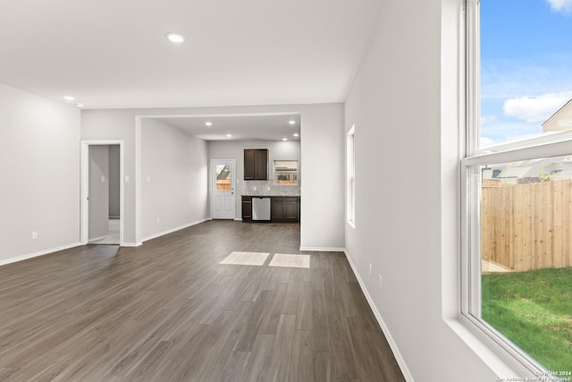 unfurnished living room featuring dark wood-type flooring and a wealth of natural light