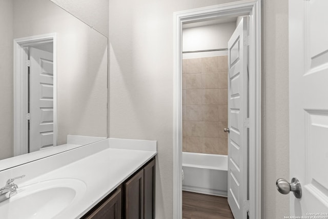 full bathroom featuring hardwood / wood-style flooring, vanity, toilet, and tiled shower / bath combo