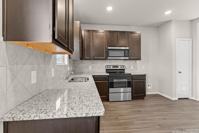 kitchen with hardwood / wood-style floors, dark brown cabinets, sink, and appliances with stainless steel finishes