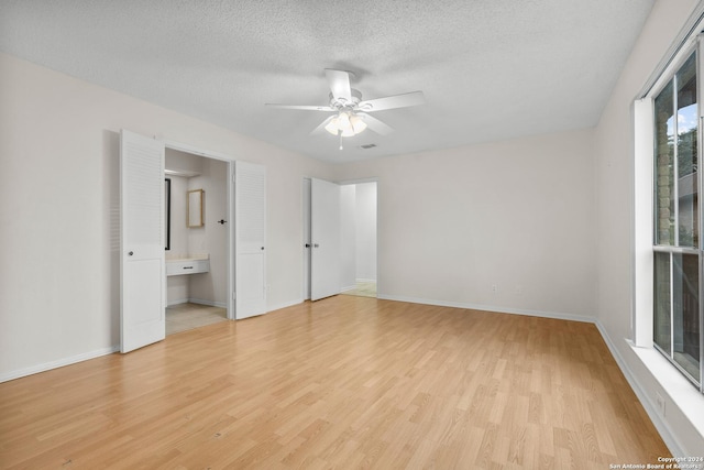 spare room featuring ceiling fan, light hardwood / wood-style floors, and a textured ceiling