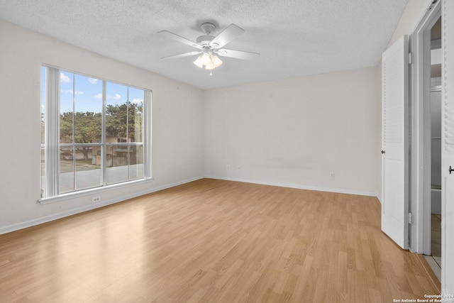 unfurnished room with a textured ceiling, light hardwood / wood-style flooring, and ceiling fan