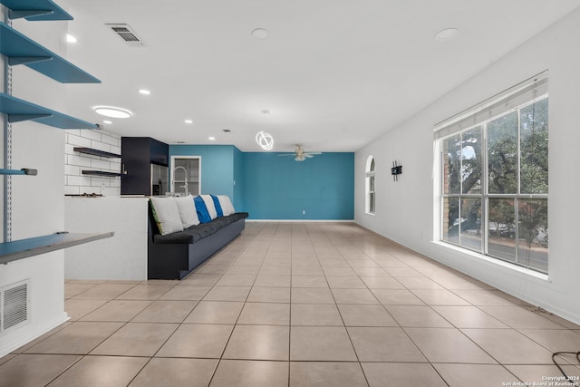 unfurnished living room featuring ceiling fan and light tile patterned flooring