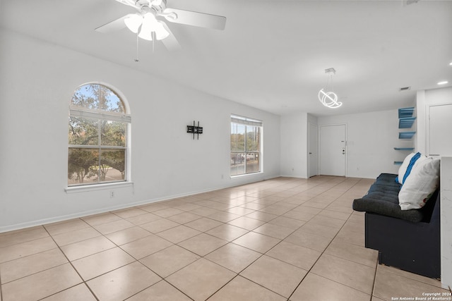 unfurnished living room featuring light tile patterned floors and ceiling fan